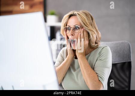 Frustrierte Geschäftsfrau, Die Auf Ihren Computerbildschirm Schaut Stockfoto