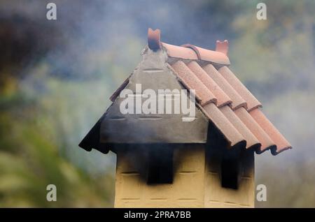 Der Schornstein stößt Rauch aus. Stockfoto