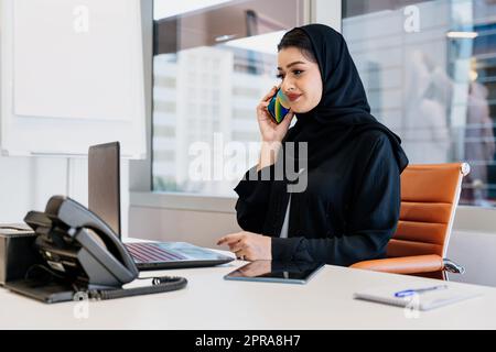 Porträt einer wunderschönen Geschäftsfrau aus dem Mittleren Osten, die Abaya trägt und im Büro in Dubai arbeitet Stockfoto