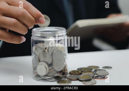 Hand hält Geld Münze sparen Investitionen in jar.Business Finance Buchhaltung Wirtschaft Konzept. Stockfoto