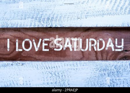 Handschrift: "I Love Saturday". Konzeptfoto, um Zuneigung für das Wochenende zu haben Happy Recon Relax wichtige Informationen geschrieben auf Piece of Wood on Floor. Stockfoto