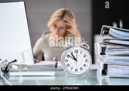Wecker Vor Der Geschäftsfrau, Die Arbeitet Stockfoto