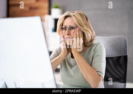 Frustrierte Geschäftsfrau, Die Auf Ihren Computerbildschirm Schaut Stockfoto