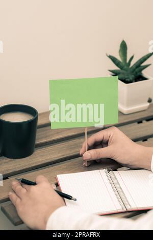 Ein Blatt Papier Mit Wichtigen Informationen Am Schreibtisch Mit Bleistiften, Notizen Und Büroklammern. Grundlegende Ankündigungen Auf Notizblock Auf Tisch Mit Bürobedarf. Stockfoto