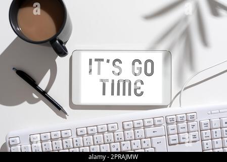 Konzeptüberschrift IT S is Go Time. Geschäftsübersicht Ein Zeitraum, in dem die zugewiesenen Aufgaben ausgeführt werden, wird AUF dem Mobiltelefonbildschirm mit wichtiger Nachricht am Schreibtisch mit Kaffee und Tastatur angezeigt Stockfoto