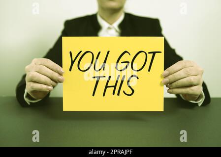 Das Schild zeigt "Du hast das" an. Business Showcase Inspiration, um es zu tun Motivation verstehen positive Einstellung Geschäftsfrau mit wichtiger Nachricht am Büroschreibtisch. Stockfoto