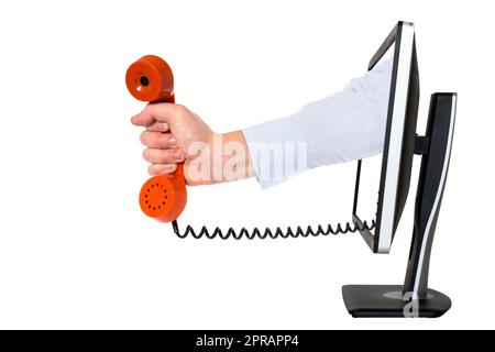 Hand mit Telefonhörer, der aus einem Computermonitor kommt Stockfoto