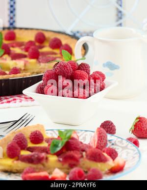 Reife rote Himbeeren in einer weißen Keramikschüssel Stockfoto