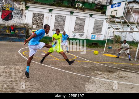 Junge afro-kolumbianische Fußballspieler spielen ein Freundschaftsspiel auf einem konkreten Spielfeld in Quibdó, Chocó, Kolumbien. Stockfoto