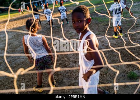 Junge afro-kolumbianische Fußballspieler spielen ein freundschaftliches Spiel während eines Trainings auf einem unbefestigten Spielfeld in Necoclí, Antioquia, Kolumbien. Stockfoto