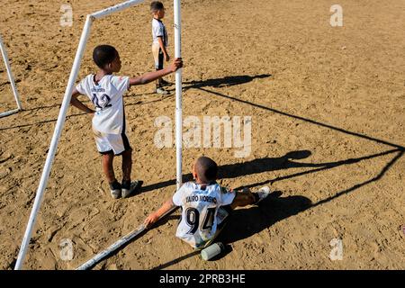 Junge afro-kolumbianische Fußballspieler sehen das Spiel während eines Trainings in Necoclí, Antioquia, Kolumbien, vom Torbereich aus. Stockfoto