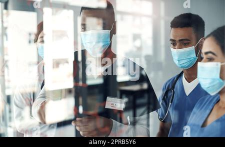 Teilen des Wissens. Schoss eine Gruppe von Ärzten, die Formeln im Büro bei der Arbeit diskutierten. Stockfoto