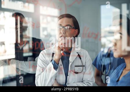 Die Chirurgen von morgen lehren. Schoss eine Gruppe von Ärzten, die Formeln im Büro bei der Arbeit diskutierten. Stockfoto