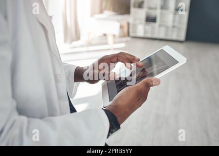 Technologie verbessert den medizinischen Bereich. Ein nicht erkennbarer Arzt, der ein digitales Tablet im Büro verwendet. Stockfoto