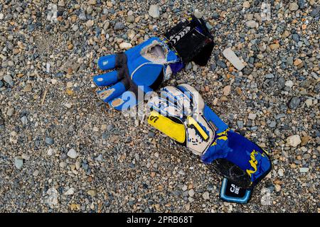 Während eines Fußballspiels in Quibdó, Chocó, Kolumbien, liegt ein Paar abgenutzter Torwarthandschuhe auf einem Spielfeld. Stockfoto