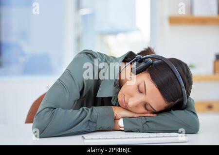 Nur ein wenig Ruhe für meine Augen. Eine erschöpfte Geschäftsfrau, die ein Nickerchen an ihrem Schreibtisch macht. Stockfoto