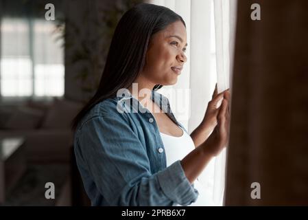 Was auch immer passiert, krank stellen Sie sicher, dass mein Baby die beste Zukunft bekommt. Eine Schwangere schaut aus dem Fenster zu Hause. Stockfoto