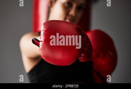 In diesen Schlägen liegt Macht. Nahaufnahme einer nicht erkennbaren jungen Boxerin, die im Fitnessstudio trainiert. Stockfoto