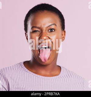 Kommen Sie auf die wilde Seite. Studioaufnahme einer jungen Frau, die vor einem rosa Hintergrund ein dummes Gesicht macht. Stockfoto