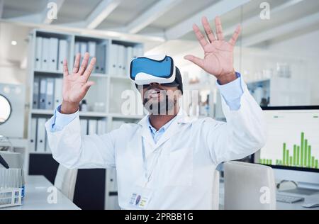 Die Interpretation von Daten auf viele verschiedene Arten. Ein reifer Wissenschaftler, der ein Virtual-Reality-Headset verwendet, während er in einem Labor arbeitet. Stockfoto