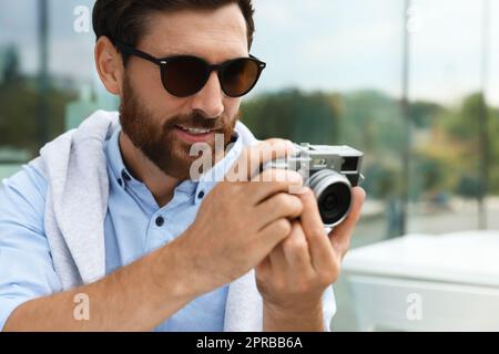 Mann mit Kamera, der draußen Fotos macht. Interessantes Hobby Stockfoto