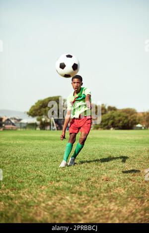 Schießen Sie für Ihre Ziele. Ein kleiner Junge Fußball auf einem Sportplatz. Stockfoto