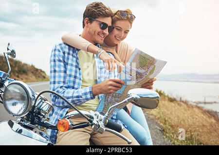 Gehen wir dorthin. Ein Paar, das eine Karte benutzt, während er unterwegs ist. Stockfoto