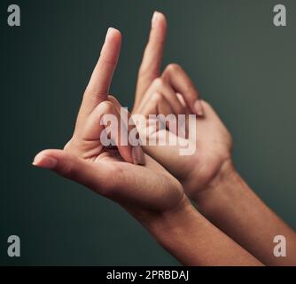 Das denke ich darüber. Studioaufnahme einer nicht erkennbaren Frau, die ihren Mittelfinger vor einem grünen Hintergrund zeigt. Stockfoto