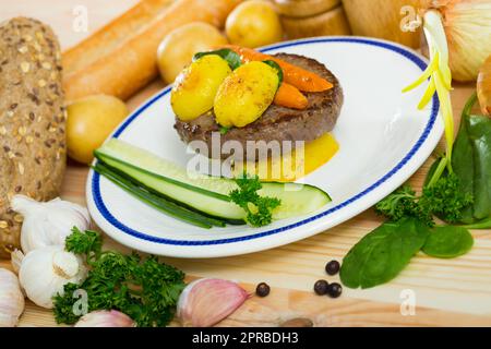 Rinderschnitzel mit gebackenen neuen Kartoffeln und Karotten Stockfoto