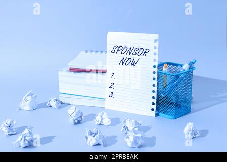 Textüberschrift „Sponsor jetzt präsentieren“. Ein Wort, das über die Bezahlung oder Investition in ein Projekt ohne Rückerstattung für Sie geschrieben wurde wichtige Idee, die auf dem „Note on Desk“ mit einem Becher mit Bleistiften und Paperwraps angezeigt wird. Stockfoto