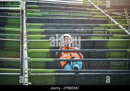 Als Projektmanagerin. Eine junge Frau, die auf einer Baustelle mit einem Walkie-Talkie arbeitet. Stockfoto