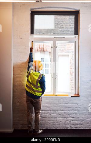 Nun müssen dieses Fenster ersetzen. Ein Ingenieur, der Messungen auf einer Baustelle nimmt. Stockfoto