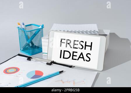 Handschrift Text frische Ideen. Überlegungen oder Vorschläge zum Geschäftskonzept wichtige Idee am Telefon am Schreibtisch mit Becher mit Bleistiften und Büchern. Stockfoto