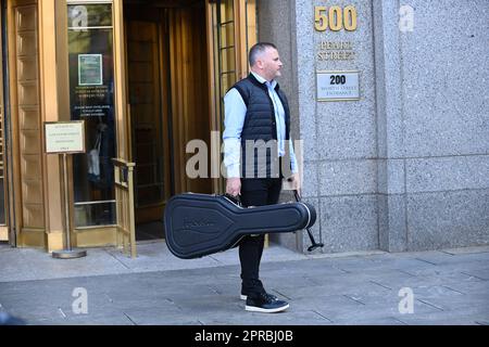 26. April 2023, New York, New York, USA: 26. April 2023 - New York, NY USA -Ed Sheeran verlässt das Bundesgericht in Manhattan nach einem weiteren Tag der Aussage in dem laufenden Verfahren, das von der Familie Marvin Gaye wegen zu enger Ähnlichkeit eines Rhythmus aus „Let's Get IT On“ gegen ihn angestrengt wurde. Er brachte heute IS Gitarre zum Gericht. Hier sieht man einen Assistenten, der seine Gitarre trägt. ( Foto: Andrea Renault/Zuma Press) (Kreditbild: © Andrea Renault/ZUMA Press Wire) NUR REDAKTIONELLE VERWENDUNG! Nicht für den kommerziellen GEBRAUCH! Stockfoto