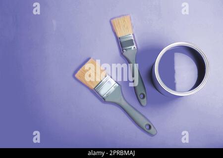 Zinndose mit Farbe und Pinsel auf violettem Hintergrund, flach verlegt. Platz für Text Stockfoto