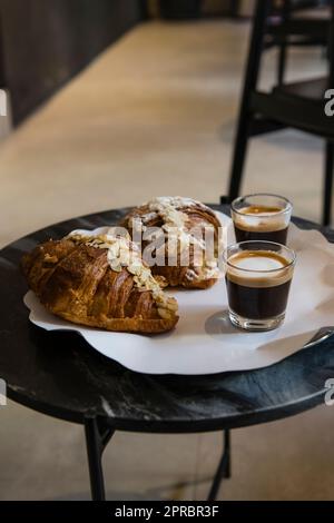 Macchiato's und Almond Croissant's auf dem Tisch, Frühstück Stockfoto