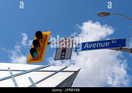 Nahaufnahme des Straßenschilds auf der Avenue mit ROM-Gebäude im Hintergrund im Zentrum von Toronto, Kanada. Stockfoto