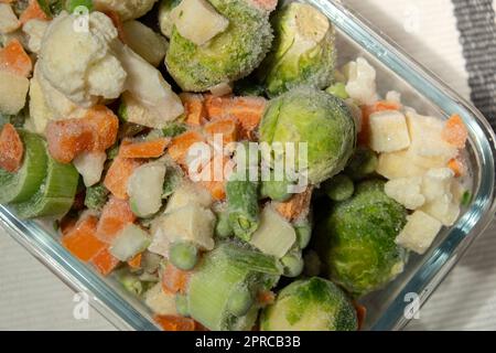 Gefrorenes gemischtes Gemüse zur Langzeitlagerung. Tiefgefrieren von Gemüse. Hintergrund für das Auftauen von gefrorenem Gemüse Stockfoto