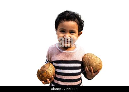 Süßer kleiner asiatischer Junge, der zwei Kokosnüsse hält, um Wasser zu trinken, mit seinem lächelnden Gesicht Stockfoto