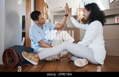 High Five, Paar und mit Erfolg und Glück nach Hause ziehen, weil wir Immobilien gekauft haben. Glückliche junge Menschen und Motivation Handgeste für Ziel und Stockfoto