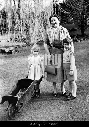 Aktenfoto vom 22. Oktober 04/54 von Prinzessin Anne, die ihre Schubkarre fährt und Prinz Charles, der sich mit seiner Großmutter, der Königinmutter, kuschelt, auf dem Gelände der Royal Lodge, Windsor, Berkshire. Das Foto wurde kurz vor ihrer Abreise nach Tobruk aufgenommen, um zu ihren Eltern, der Königin und dem Herzog von Edinburgh, nach Hause von der Commonwealth-Tour zu reisen. Die Nachrichtenagentur der PA hat Fotos von jedem Jahr des Königs zusammengestellt, um Karls III. Krönung zu feiern. Ausgabedatum: Donnerstag, 27. April 2023. Stockfoto