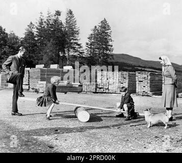 Das Foto des Prinzen von Wales mit seiner Schwester Prinzessin Anne aus dem Jahr 15/09/57, das von ihren Eltern Queen Elizabeth II. Und dem Herzog von Edinburgh genau beobachtet wurde und mit Hilfe ihres Vaters auf einer Säge aus Holz und einer Holzplanke spielte. Jedes Jahr zieht sich die Königin in den Sommermonaten nach Balmoral in Aberdeenshire zurück. Die Nachrichtenagentur der PA hat Fotos von jedem Jahr des Königs zusammengestellt, um Karls III. Krönung zu feiern. Ausgabedatum: Donnerstag, 27. April 2023. Stockfoto
