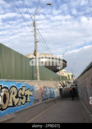 Eine enge Passage zwischen den Zäunen, eine moderne Unterführung mit einem Tunnel mit ungezwungenem Graffiti in einer modernen Stadt in einem Slum, einem armen Viertel. Georgien, Stockfoto