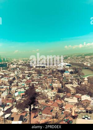 Vertikaler Blick von der Spitze einer wunderschönen Touristenstadt mit Gebäuden und Häusern, Dächern von Bäumen und Pflanzen, Natur vor dem blauen Himmel Stockfoto