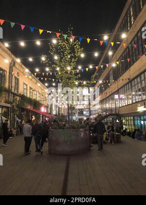 Die Leute gehen entlang der modernen Fußgängerzone in der Nacht mit Flaggen und Glühbirnen, Boutiquen mit Cafés, Bars und Restaurants im Stadtzentrum. Georgia, Fledermaus Stockfoto