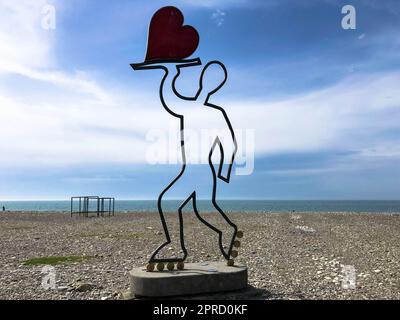 Abstrakte Statuen, kleine architektonische Formen mit einem Mann, der ein Herz auf Rollschuhen auf dem Batumi Seaside Boulevard oder Batumi Beach hält. Georgien, Batumi, Stockfoto