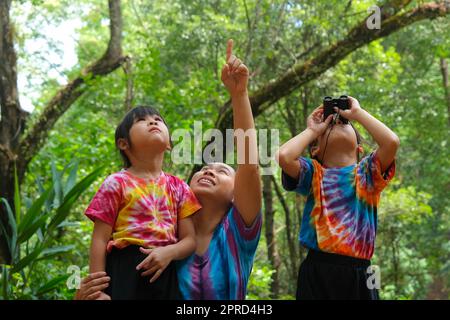 Mutter und Tochter machen Aktivitäten, während sie Ferngläser im Urlaub zusammen anschauen. Mutter und zwei Töchter wandern mit Fernglas zum Studium. Lernen Stockfoto