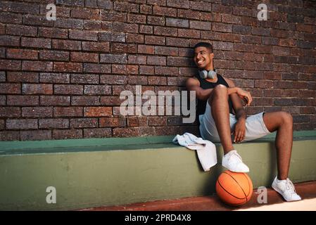 Ich glaube an Schießen für Ihre Ziele. Ein sportlicher junger Mann, der nach einem Basketballspiel eine Pause einnahm. Stockfoto