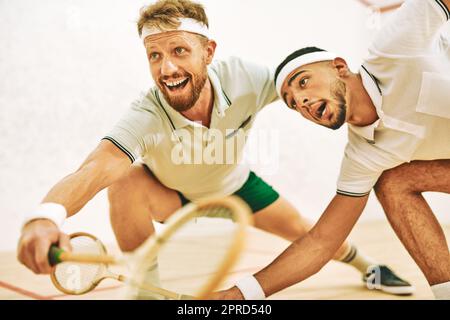 Jede Sekunde zählt auf dem Squashplatz. Zwei junge Männer spielen Squash. Stockfoto