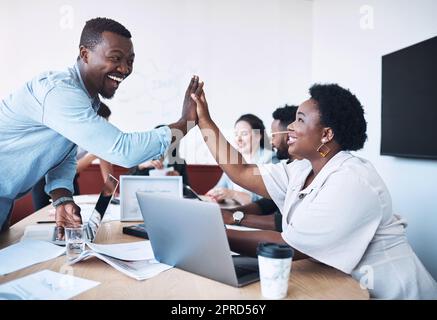 Teamwork macht den Traum wirklich zum Erfolg. Zwei Geschäftsleute geben sich bei einer Besprechung in einem Sitzungssaal eine hohe fünf. Stockfoto